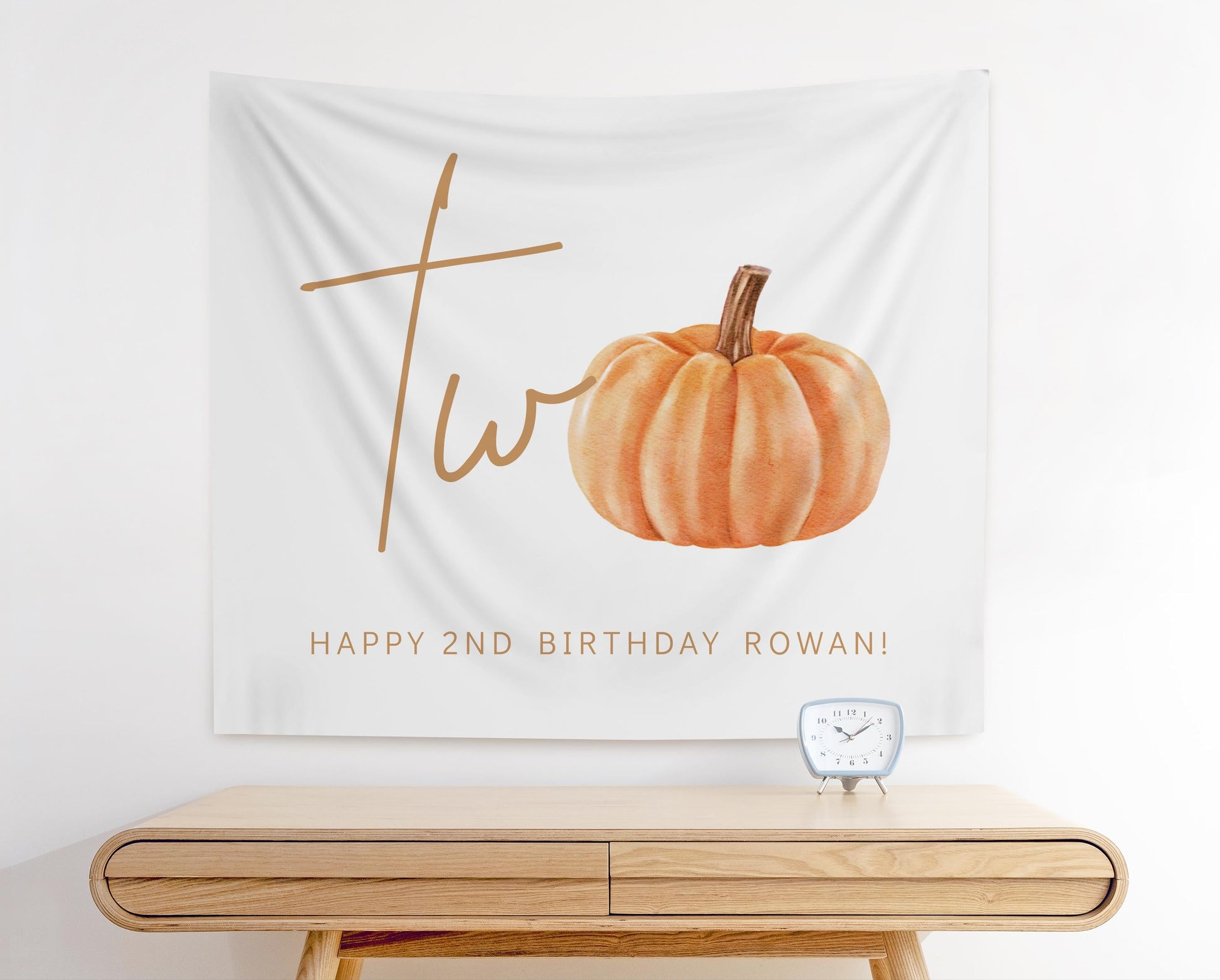 minimalist fabric backdrop.  white background and "two" with a pumpkin watercolor graphic representing the "o".  Below reads "Happy 2nd Birthday Rowan!"
