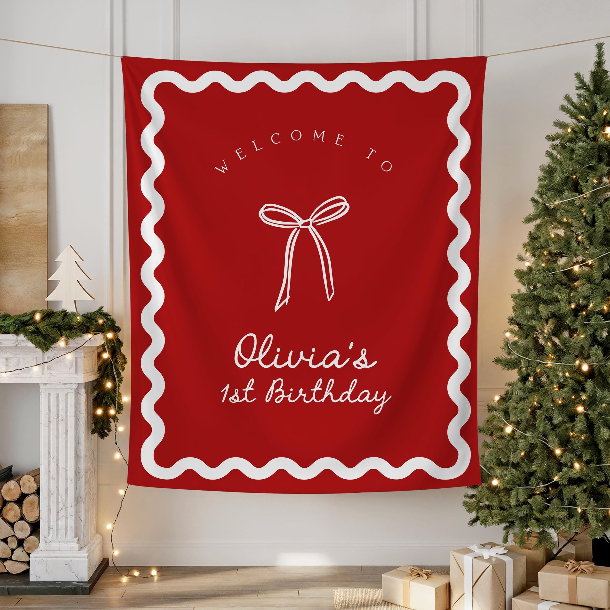 Red Christmas birthday backdrop with white wavy border, coquette bow graphic, and text “Welcome to Olivia&#39;s 1st birthday” hanging on wall.
