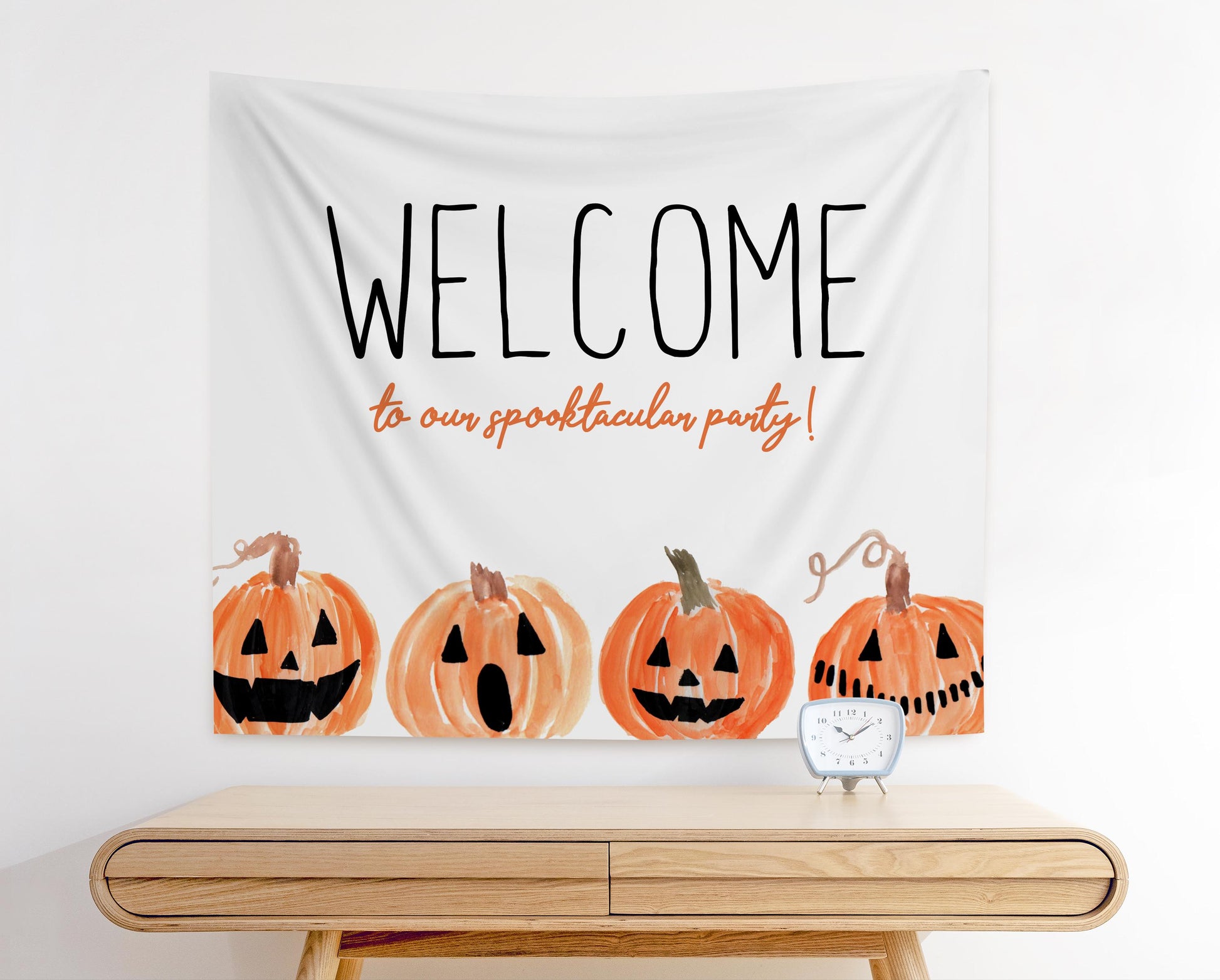 halloween party fabric banner backdrop welcome sign.  white background with playful jack o lantern pumpkins along bottom.  In playful fonts it reads "WELCOME to our spooktacular party!"