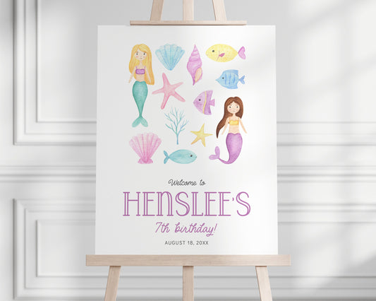 modern mermaid party welcome sign with pastel watercolor graphics of mermaids, sea shells, fish and coral displayed on easel for birthday party entrance