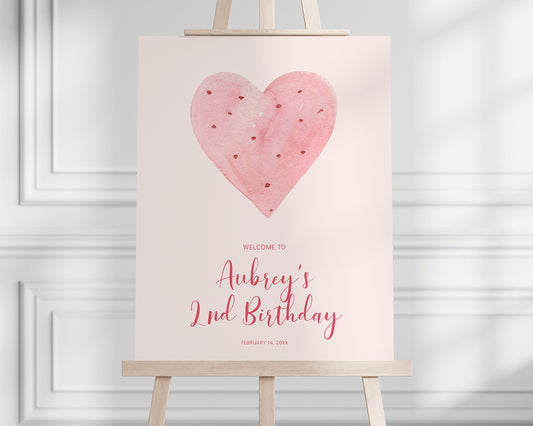 Boho Valentine Heart Girl Birthday Party Welcome Sign.  Pale pink background, minimalist design with watercolor pink and red heart graphic.  Sign rests on easel.  Editable Sign template.
