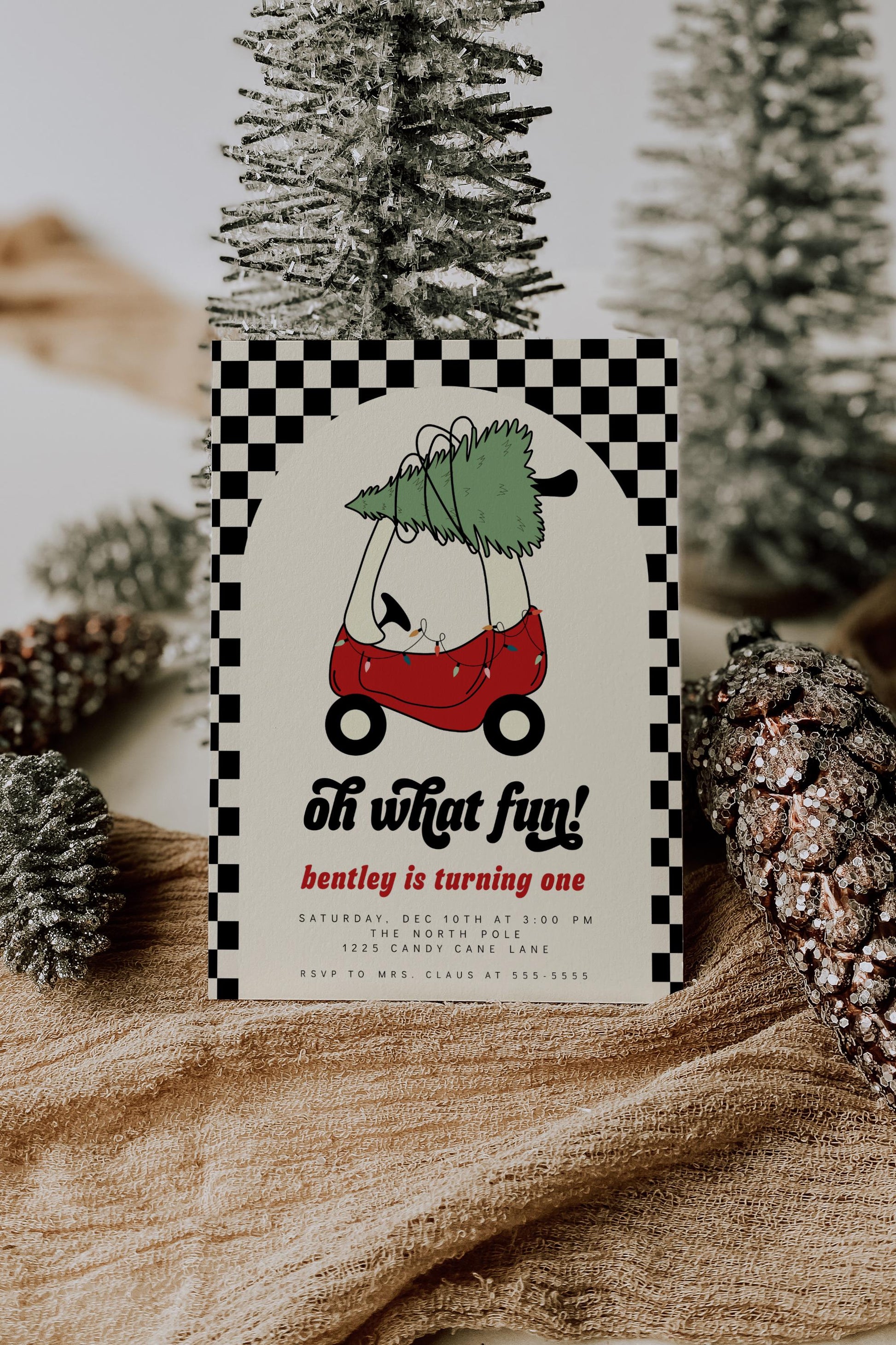 christmas first birthday invitation with red toy car hauling a christmas tree.  black checkered pattern background.