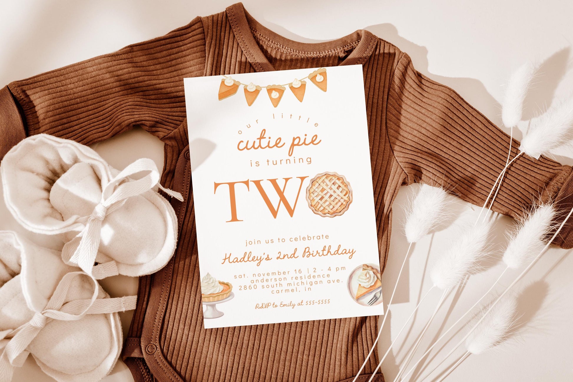 cutie pie is TWO birthday invitation for second birthday party.  White invitation with fall thanksgiving inspired graphics of pumpkin pie slice bunting, pumpkin pies with whipped cream.  Reads "our little cutie pie is TWO".  The "O" is replaced with a pie graphic.