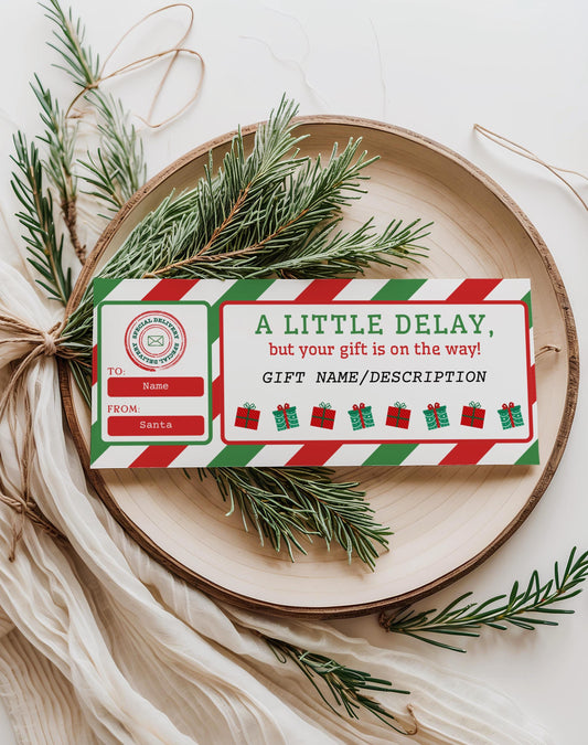 Editable Christmas gift delay certificate template in red and green stripes displayed on a holiday tray with pine branches; printable Canva late gift note