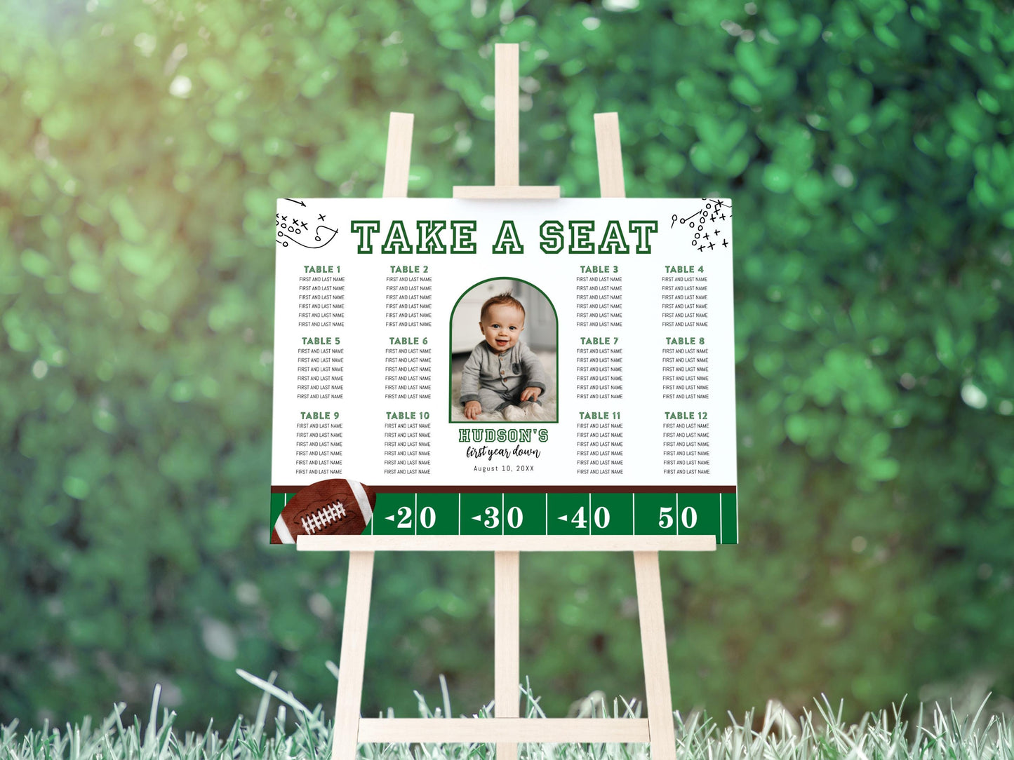 football first year down birthday party seating chart on easel.  reads "take a seat" and features photo in center.  table numbers and guest names surround each side.