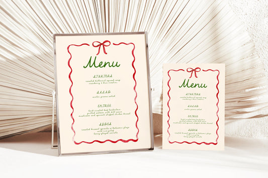 wavy red ribbon border and bow on beige cream background.  Menu in green handwritten font with vintage feel.  8x10 menu in frame next to 5x7 menu card.