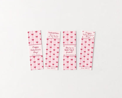 Pink bow Valentine bookmark printables with striped bow pattern and Valentine sayings, styled on a clean white background in a minimalist flat lay.