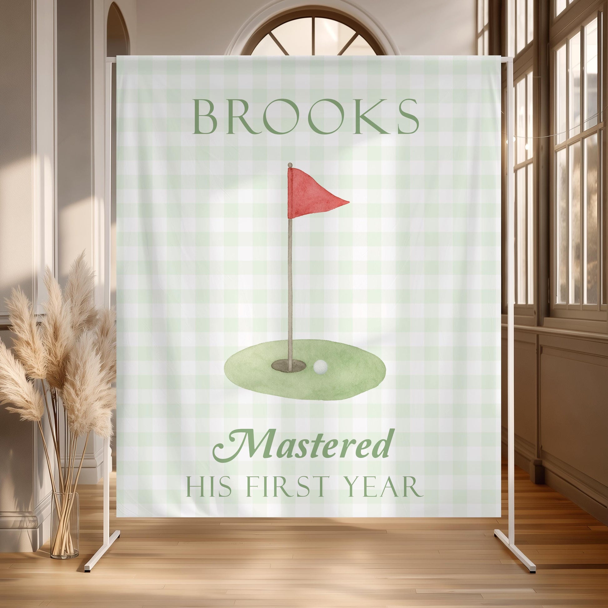 Personalized golf first birthday fabric backdrop with sage green gingham, watercolor golf flag and “Mastered His First Year” design.