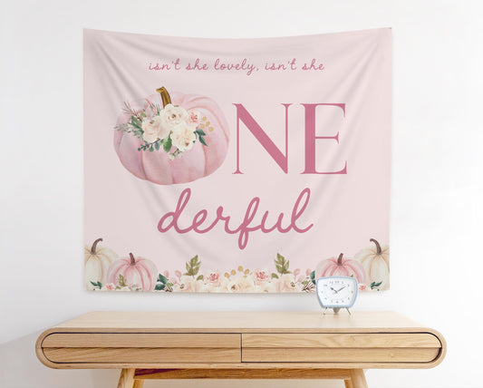 Boho floral pumpkin first birthday backdrop with blush pumpkins, flowers, and text “Isn’t She Lovely, Isn’t She ONEderful”