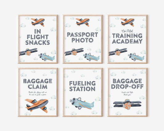 set of 6 framed party signs for airplane themed birthday.  modern minimal design of navy blue, turquoise and orange watercolor plane and cloud graphics.  In-flight Snacks, Passport Photo, Co-Pilot Training Academy, Baggage Claim, Fueling Station and Baggage Drop-off